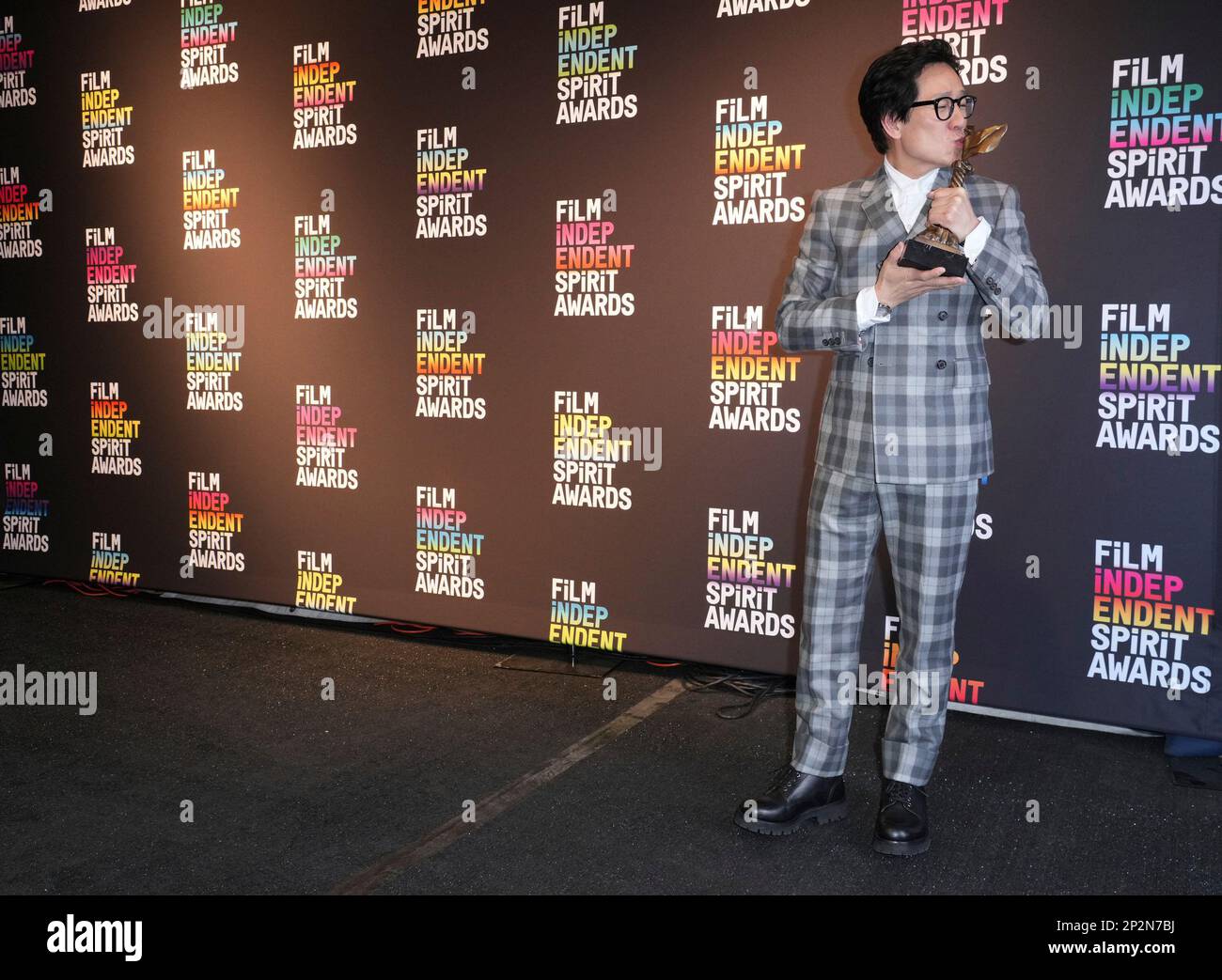 Ke Huy Quan poses in the press room with the award for best supporting ...