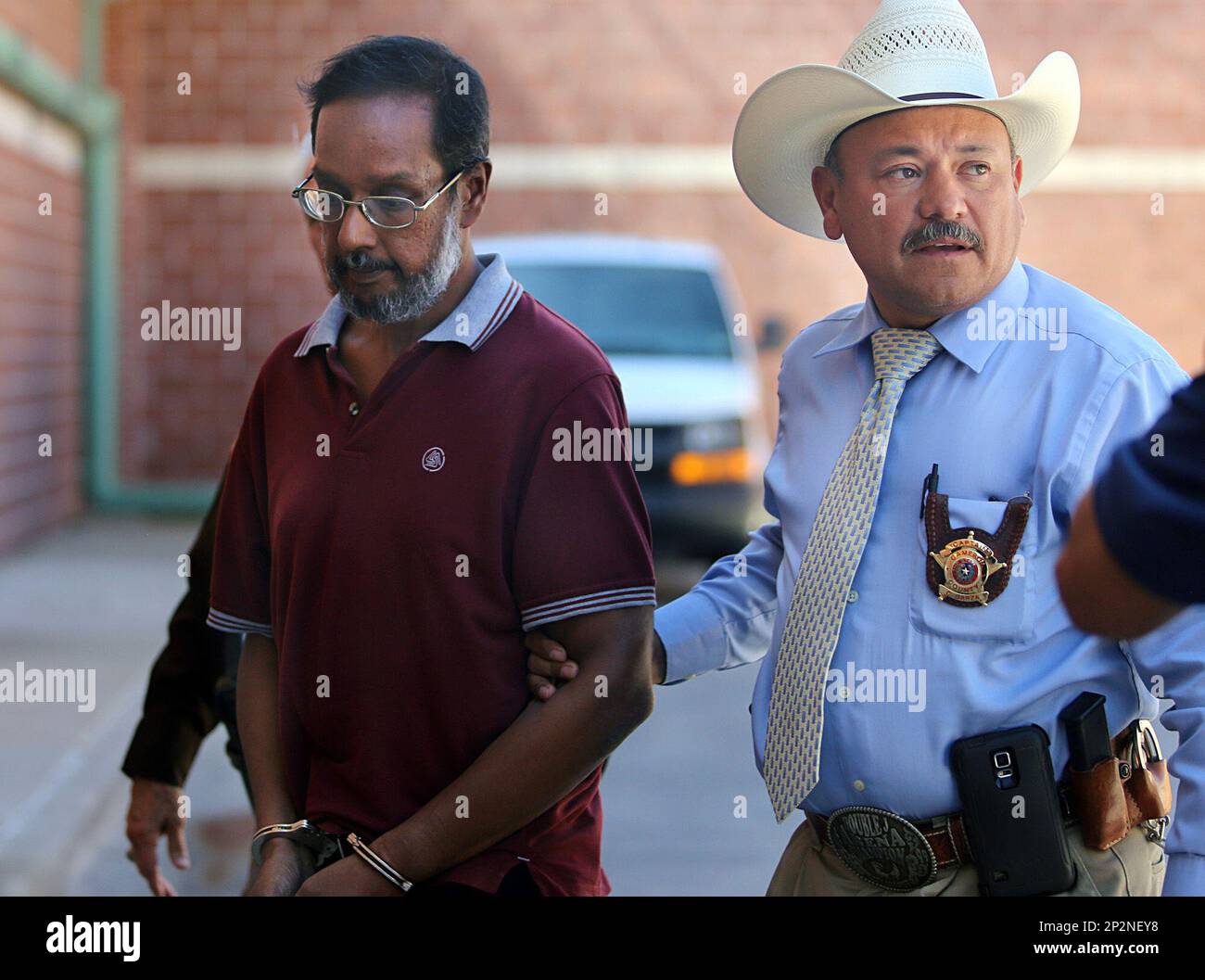 Captain Carlos Garza escorts Amit Livingston, left, into the booking