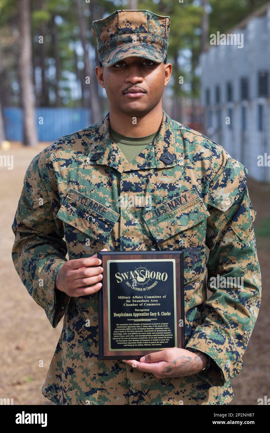 U.S. Navy Hosiptalman Gary Clarke with 2nd Medical Battalion, 2nd Marine Logistics Group, poses for a portrait with the Swansboro Area Chamber of Commerce Award after an award ceremony on Camp Lejeune, North Carolina, Feb. 9, 2023. The Swansboro Area Chamber of Commerce Award aims to recognize outstanding service members for their knowledge, skills, and work ethic. Stock Photo