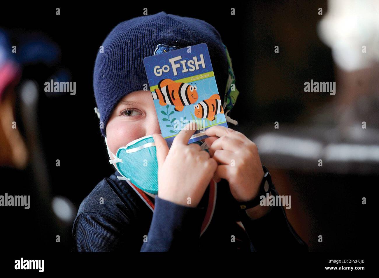 Josh Hardy hides his cards while playing Go Fish with his brothers Jude and Joe at the family's Fredericksburg home on Friday, Jan. 2, 2014. Hardy came home from the St. Jude Children's Research Hospital in Memphis, Tenn. Nov. 18 after battling a deadly infection he developed after a bone marrow transplant. (Peter Cihelka/The Free Lance-Star via AP) Stock Photo