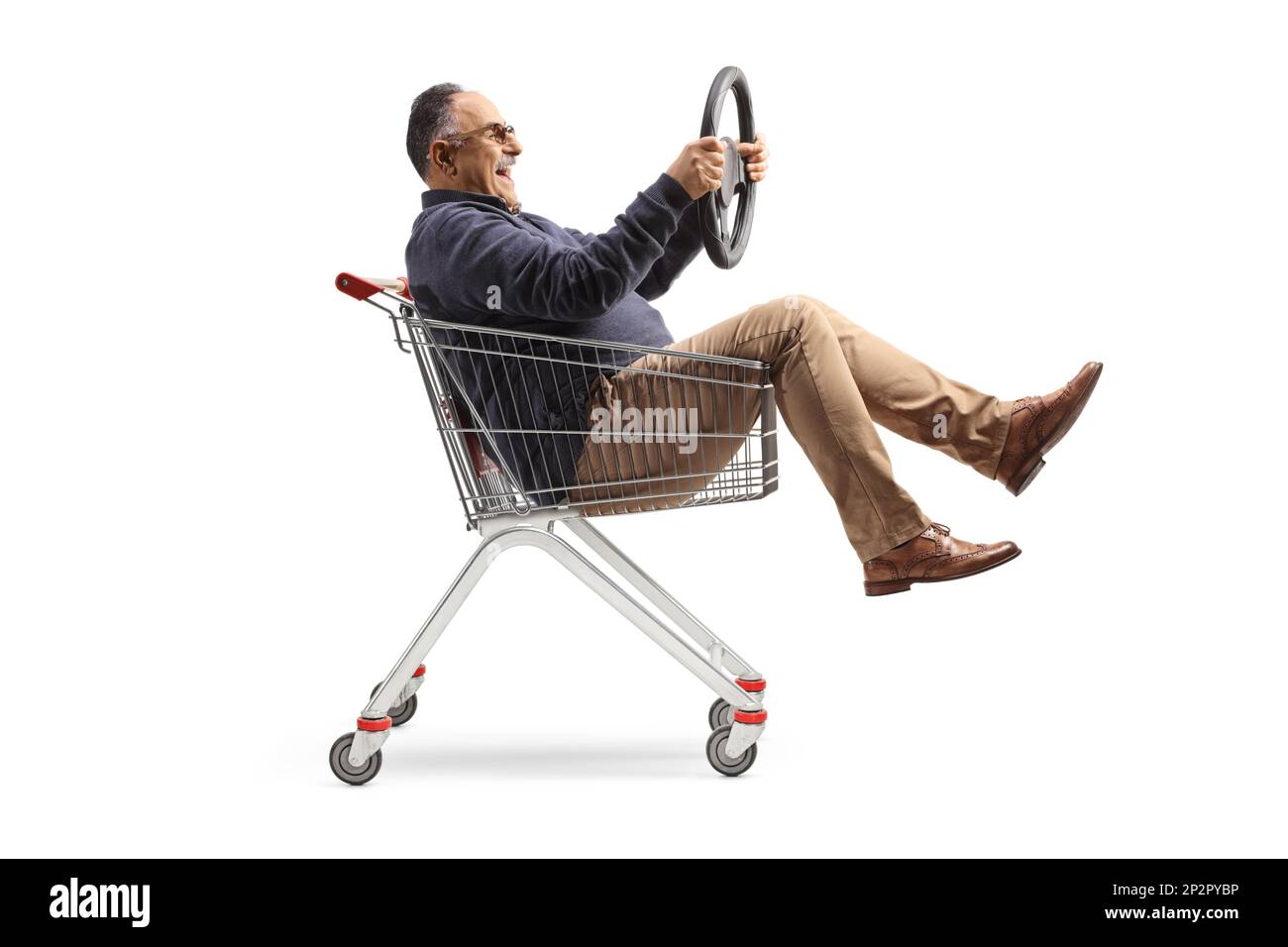 Funny mature man inside a shopping cart holding a steering wheel