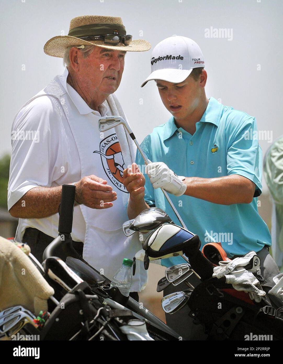 Parker Coody discusses club selection with his grandfather and caddie