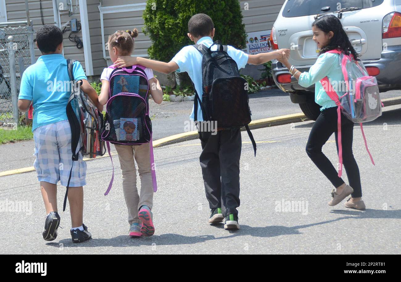 A group of children walk hand in hand after being dismissed from West