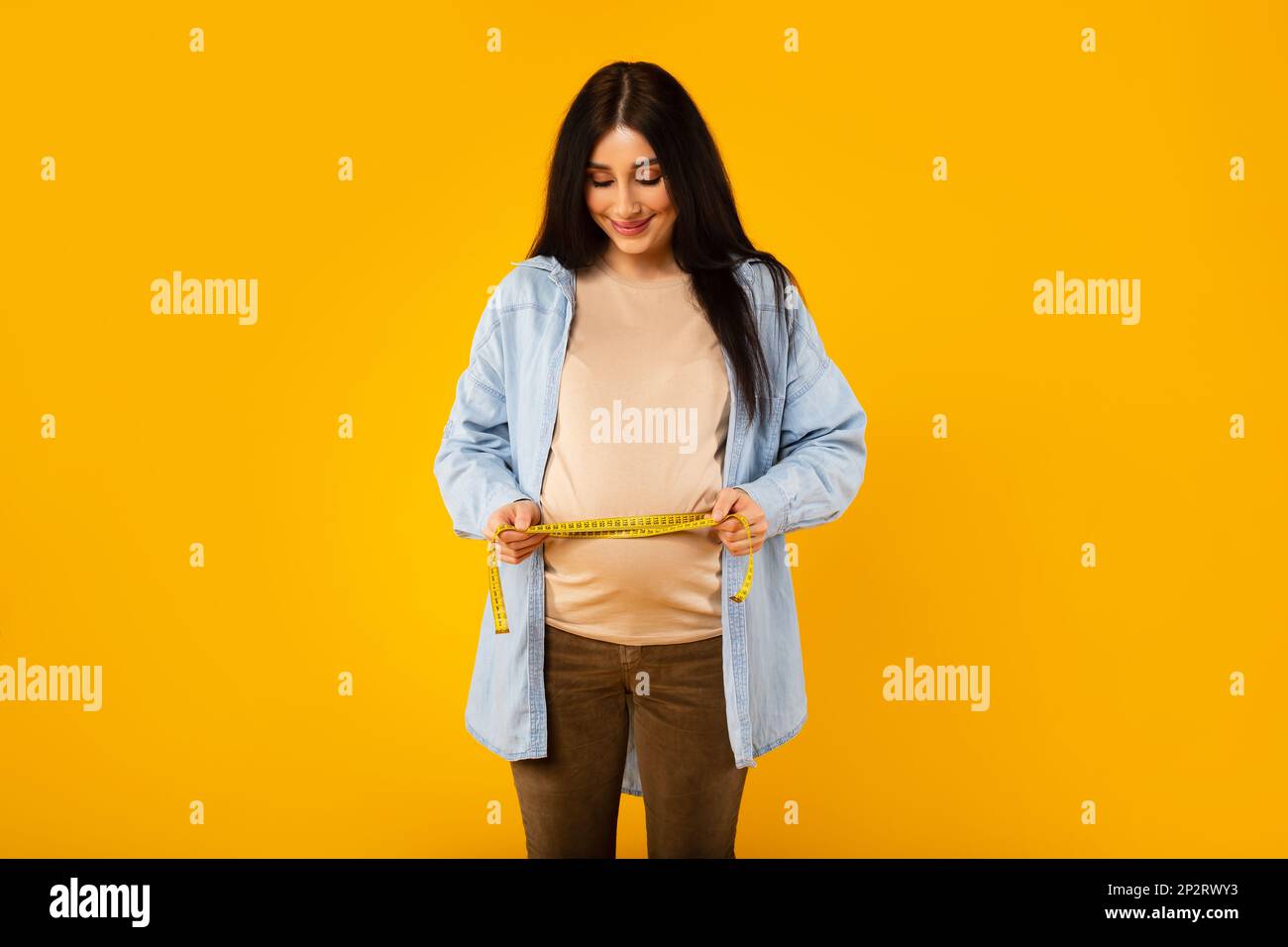 Happy pregnant woman measuring big belly at last trimester of pregnancy ...