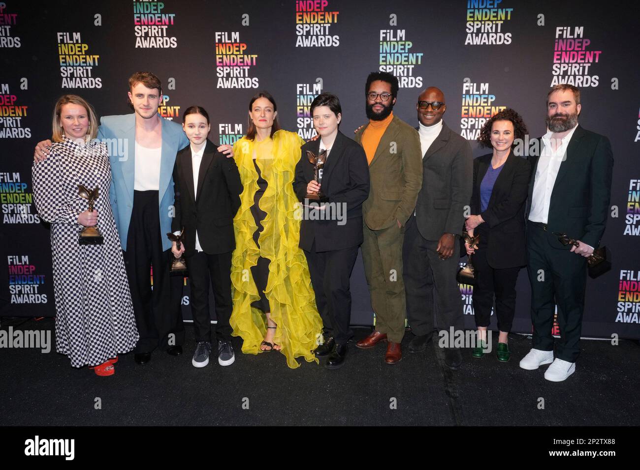 The cast and crew of "Aftersun" pose in the press room with the award for best first feature at
