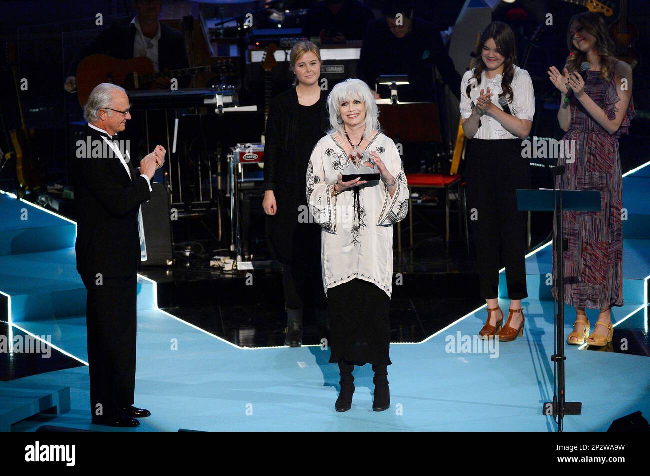 American singer and songwriter Emmylou Harris, centre, displays her trophy after she received