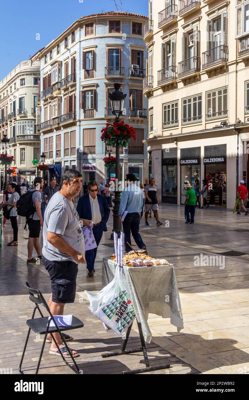 Malaga, Spain - June 18th 2018.  Man selling nuts on Calle Marqués de Larios.. The city is the capital of a province with the same name Stock Photo