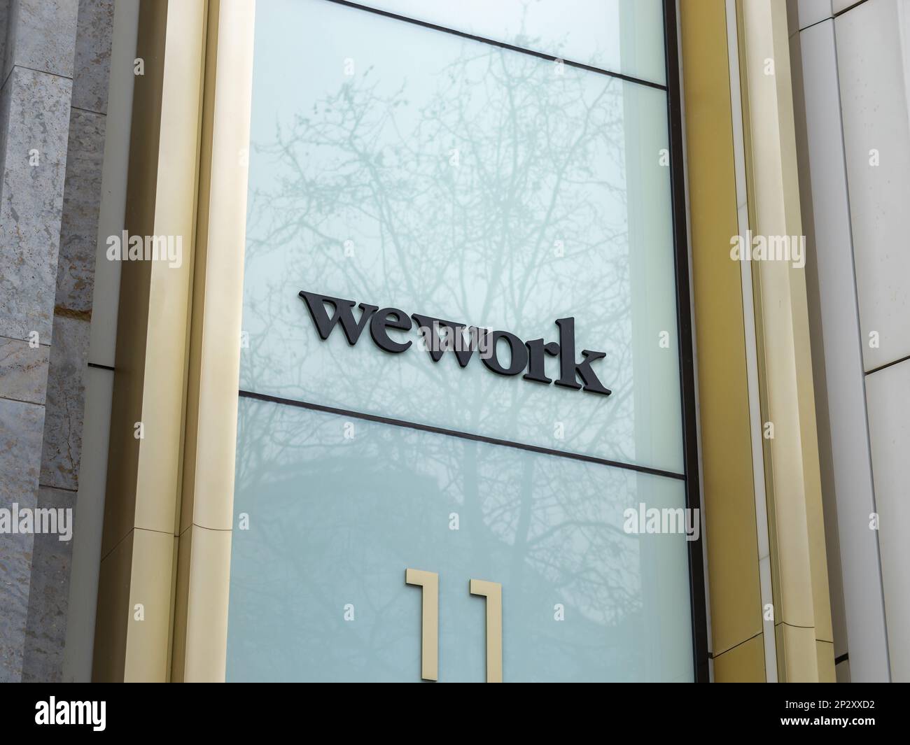 WeWork logo on a building exterior. Provider of co-working office spaces and shared spaces in the city of Berlin. American start up company. Stock Photo