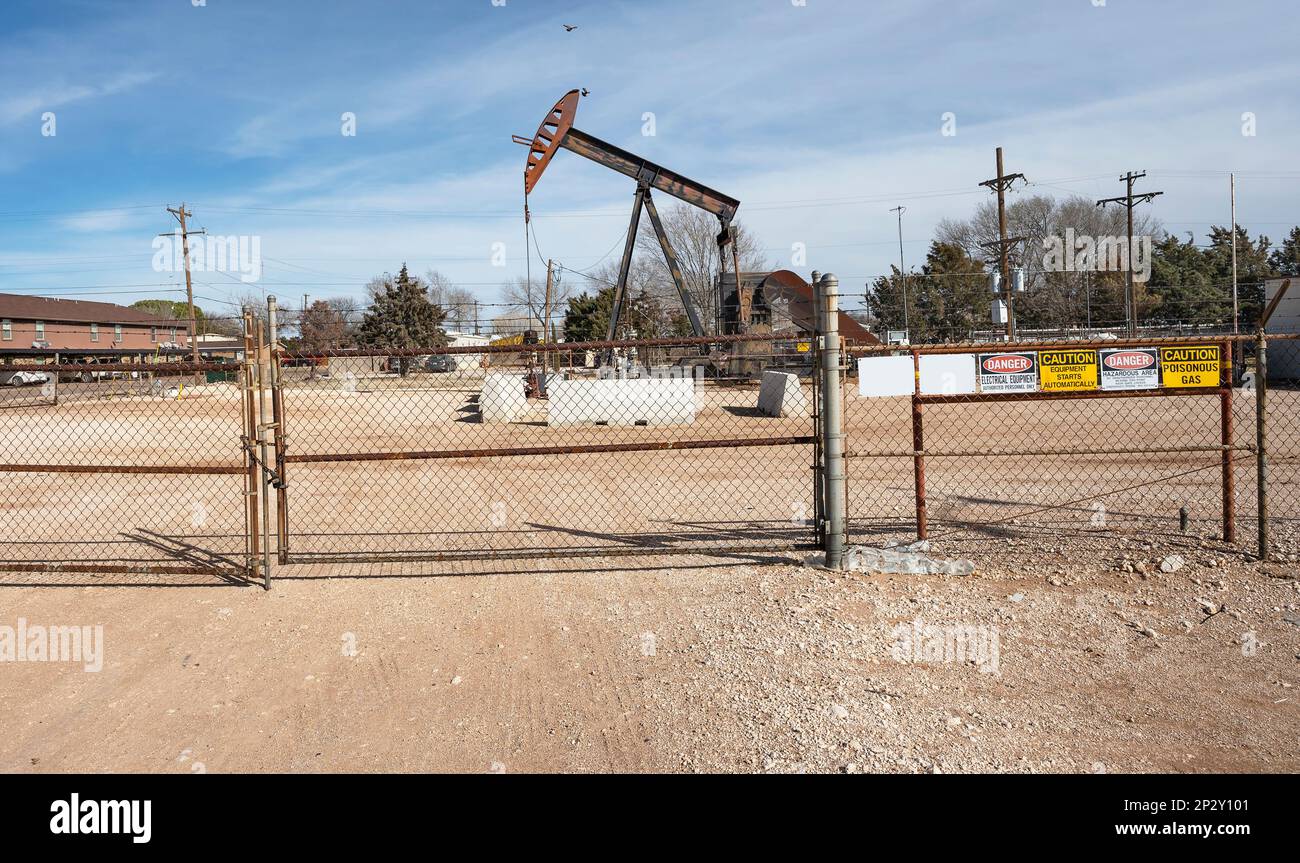 Fenced oil pumpjack in downtown Denver City, Texas, USA Stock Photo