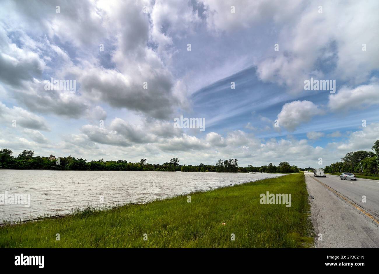Cars pass flood waters on U.S. 69 on Sunday, May 17, 2015, in Mosby, Mo