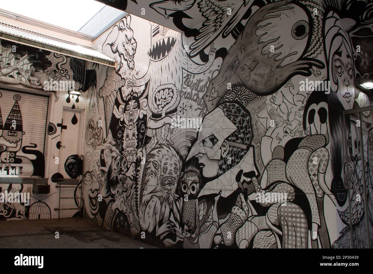 Creative black and white graffiti street art mural lining the street of ...