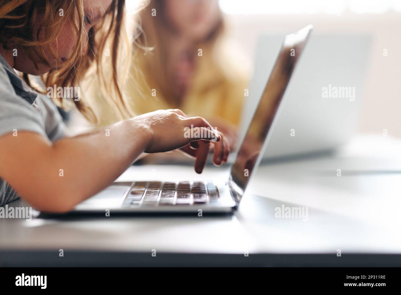 Young boy using a laptop to do a digital literacy task in a classroom