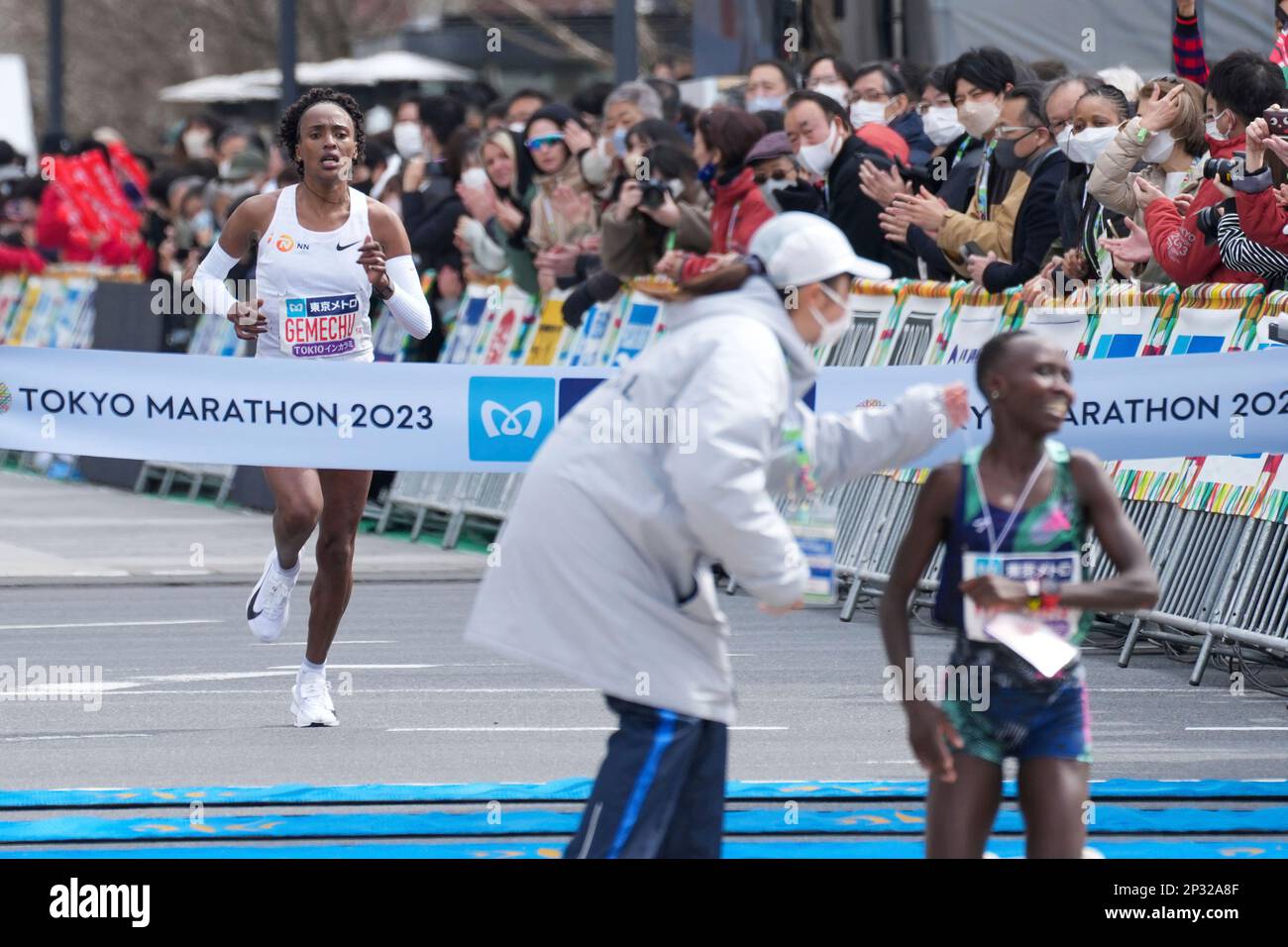 Tsehay Gemechu, left, of Ethiopia crosses the finish line for the