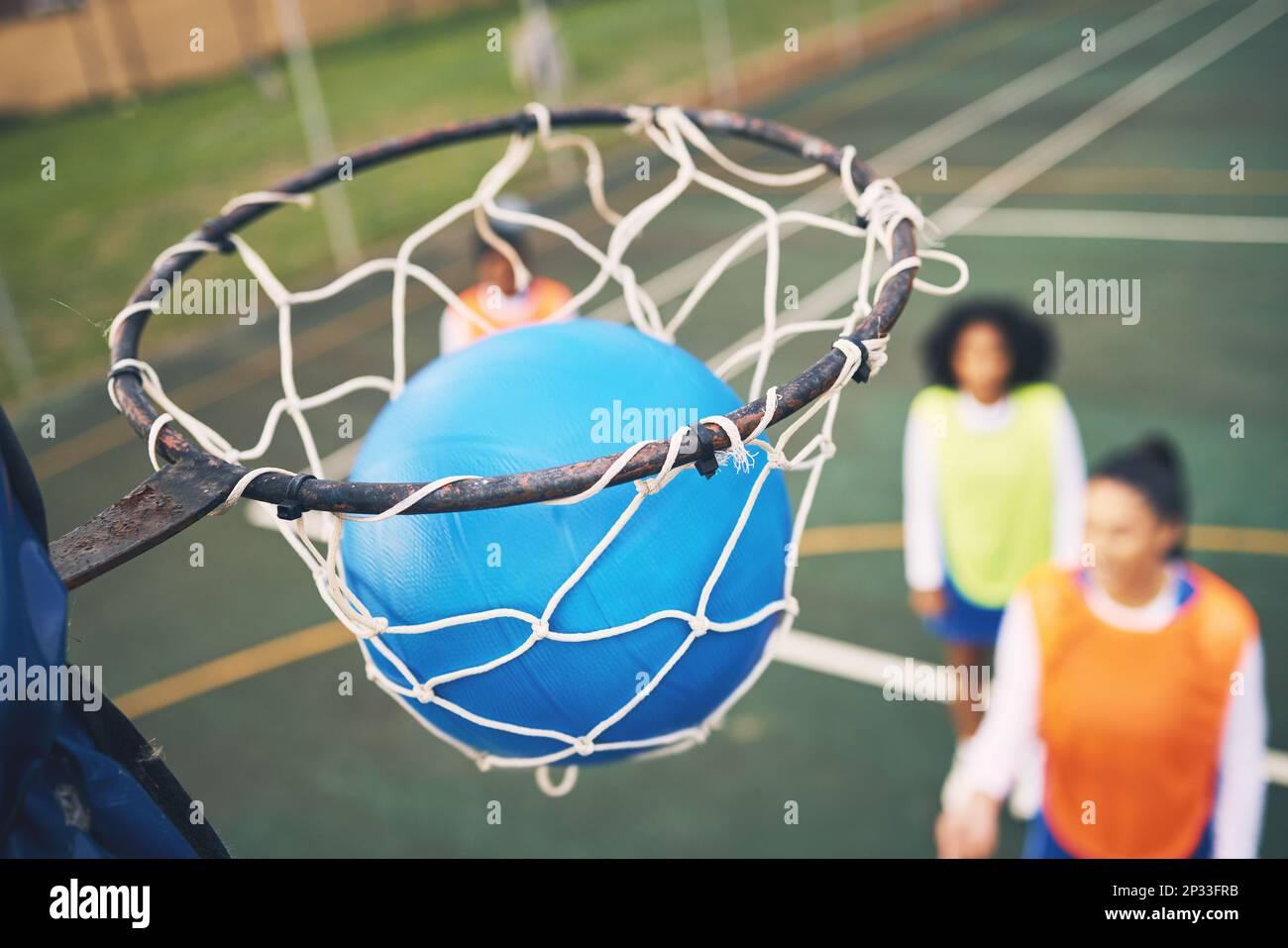 Ball in net, netball and sports outdoor with team, fitness and active lifestyle with athlete on court. Sport, professional club and people playing Stock Photo