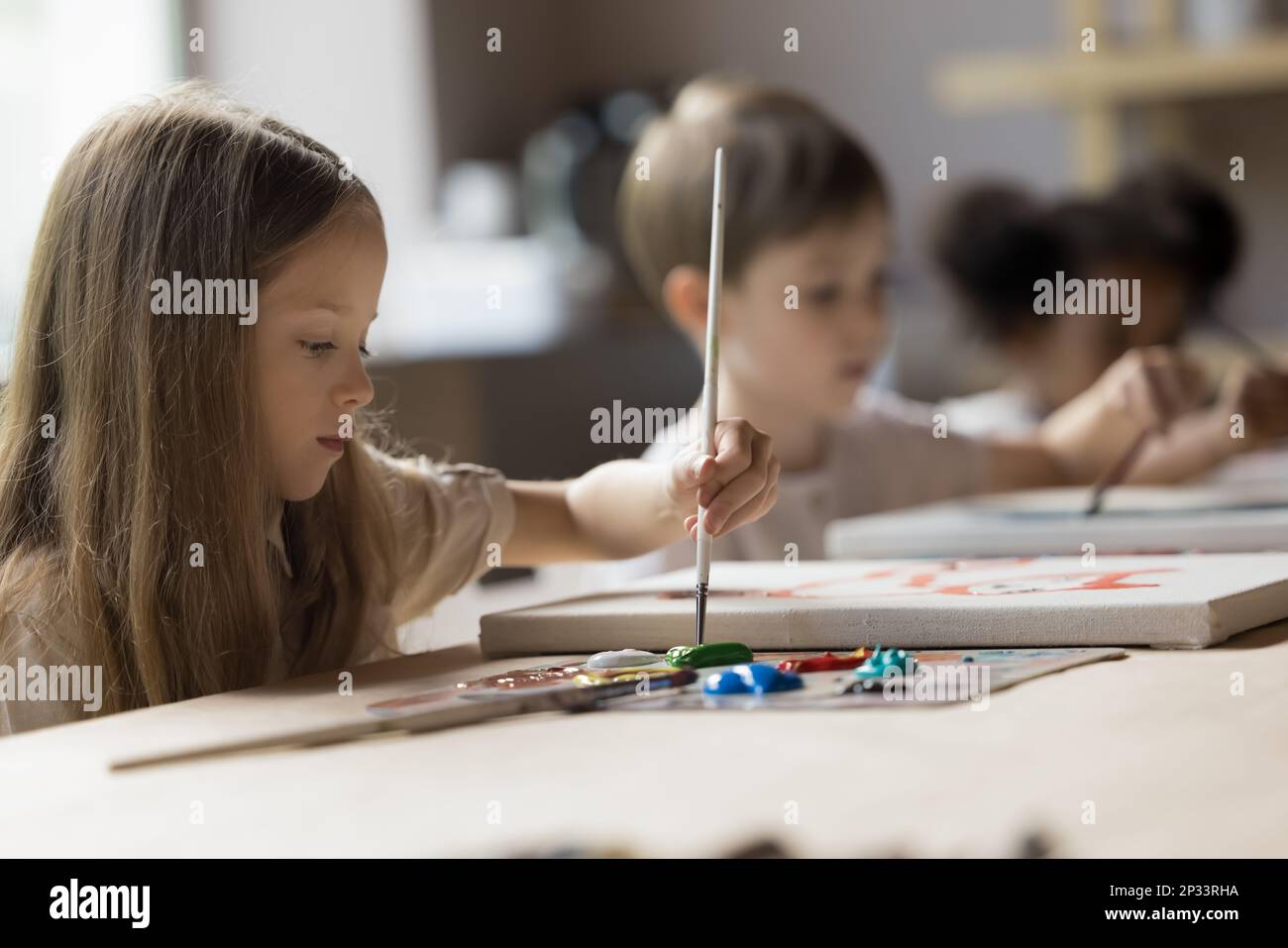 Serious sweet little girl mixing oil paints on palette Stock Photo - Alamy