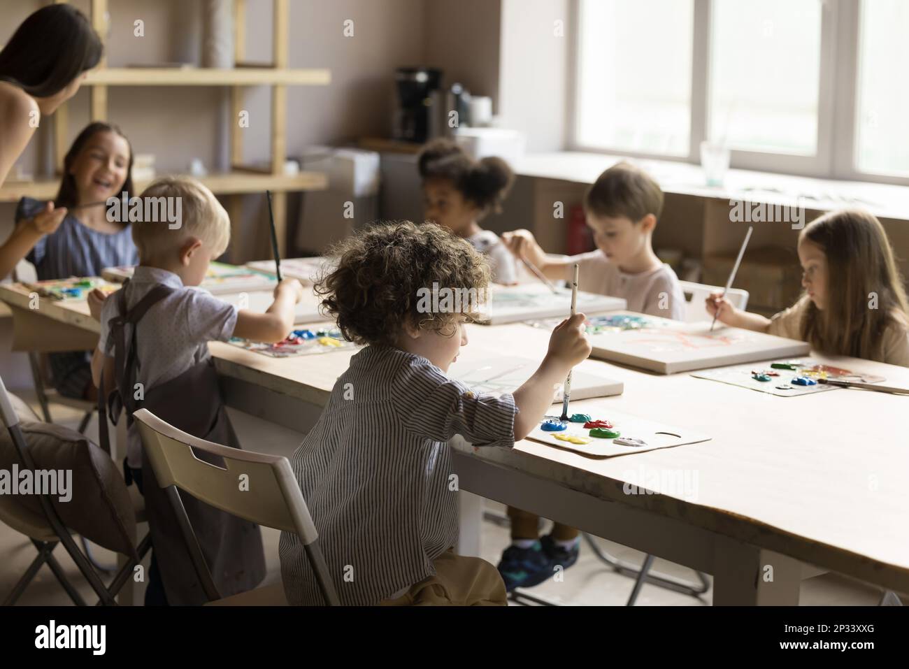 Group of little artistic school pupils drawing in acrylic colors Stock Photo