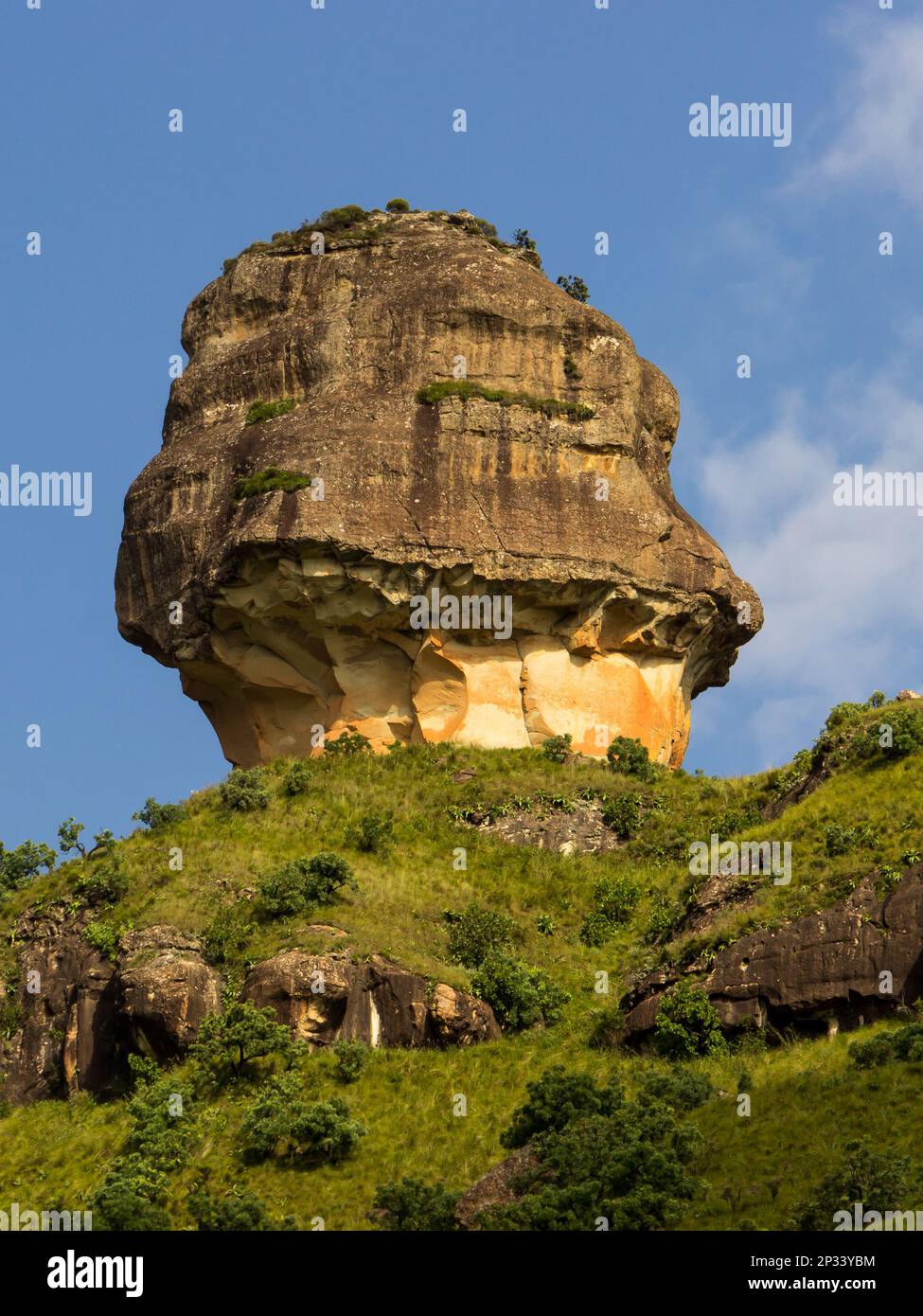 The bizarre sandstone buttress, called Policeman’s Helmet, in the Drakensberg Mountains, Royal Natal national park, South Africa, against a blue sky. Stock Photo