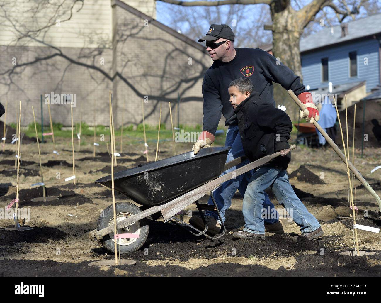 Erie, Pa. resident Jose Suarez, 7, pushes a wheelbarrow of mulch with