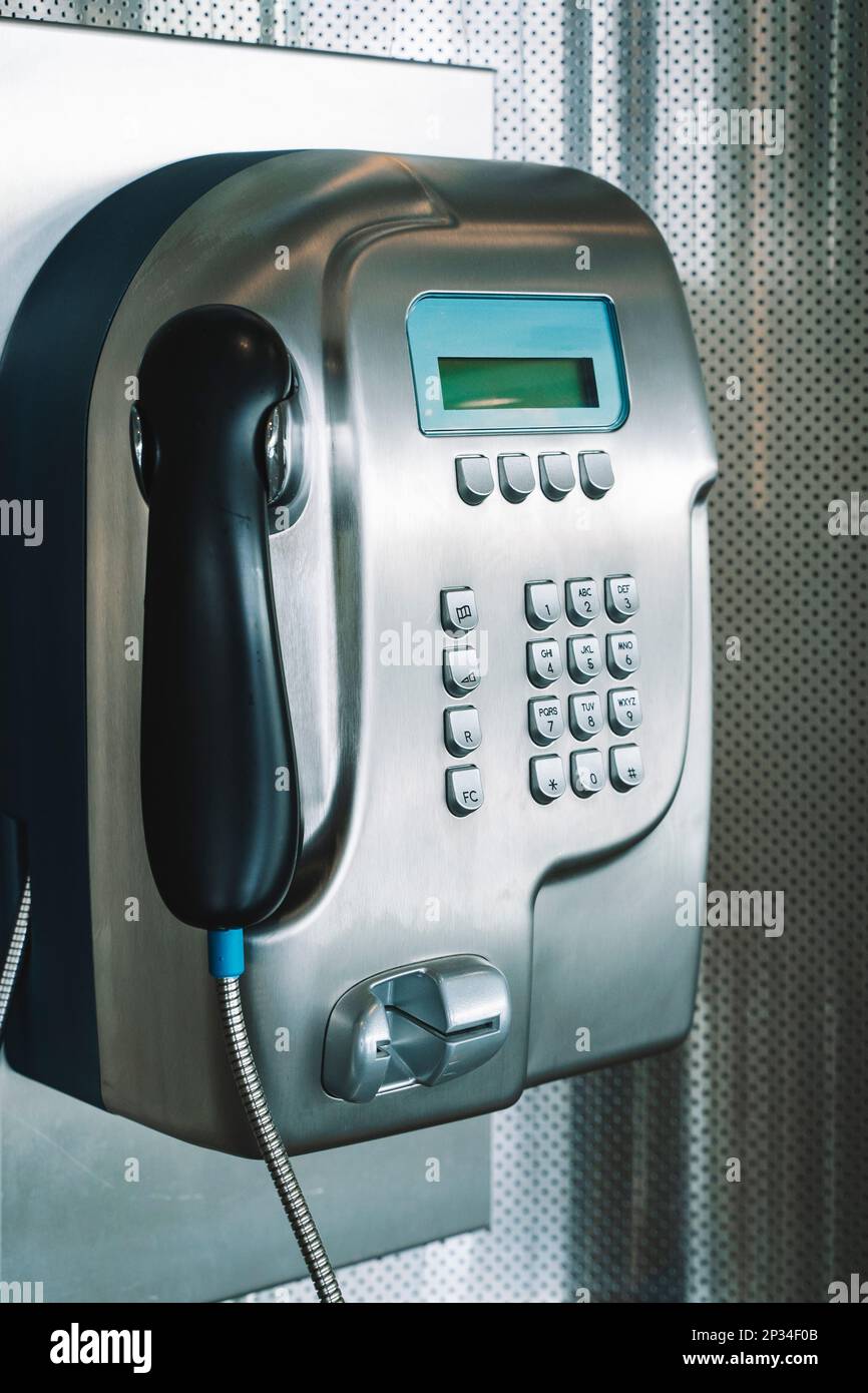 Payphone on the wall. Modern payphone for paid calls in a public place. High quality photo Stock Photo