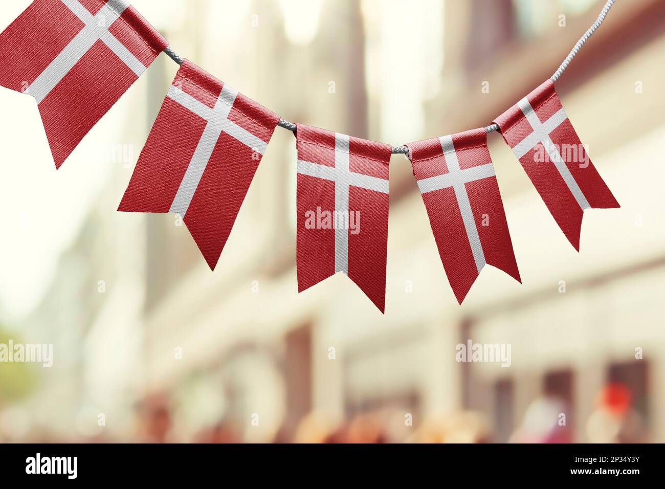 A garland of Denmark national flags on an abstract blurred background
