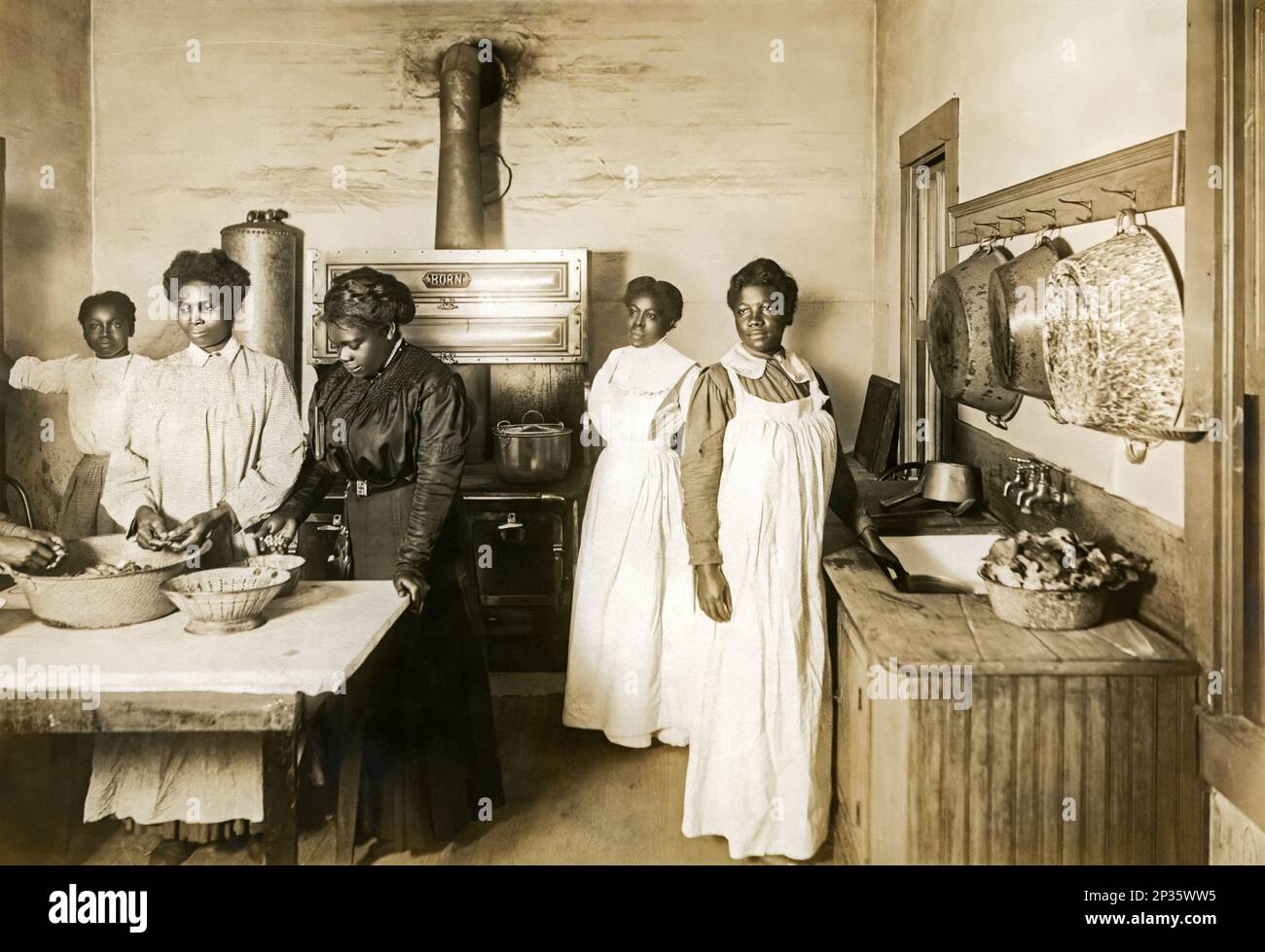 Mary McLeod Bethune (third from left) during meal preparation with students at her Daytona Normal and Industrial Institute for Girls about 1912 in Daytona Beach, Florida. Stock Photo