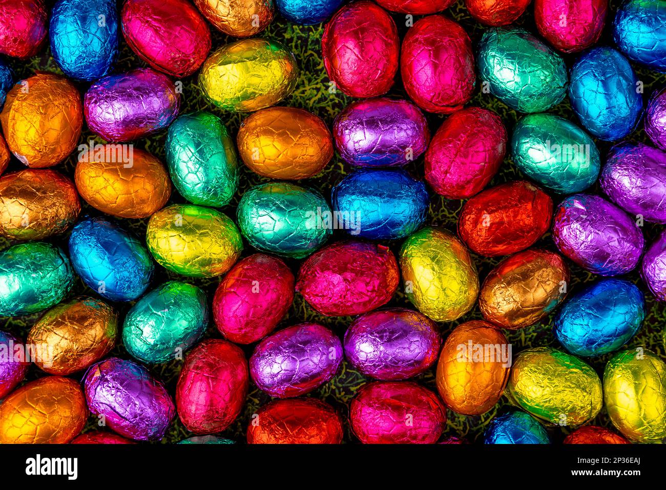 Colourful Easter candy on grass, chocolate eggs, full size Stock Photo