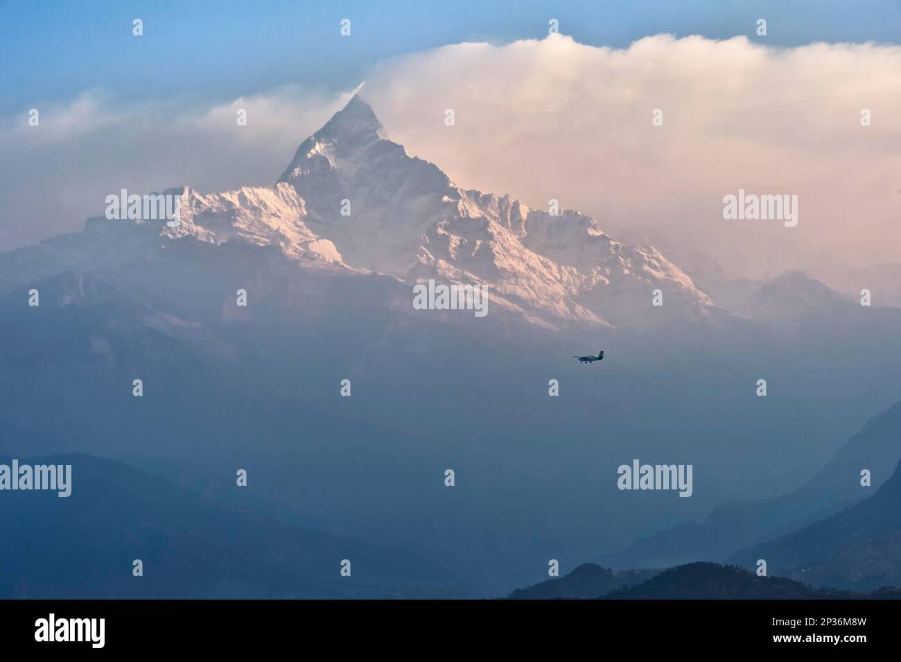 Small plane flies to sacred peak Machhapuchhare Fishtail Mountain, Pokhara, Nepal Stock Photo