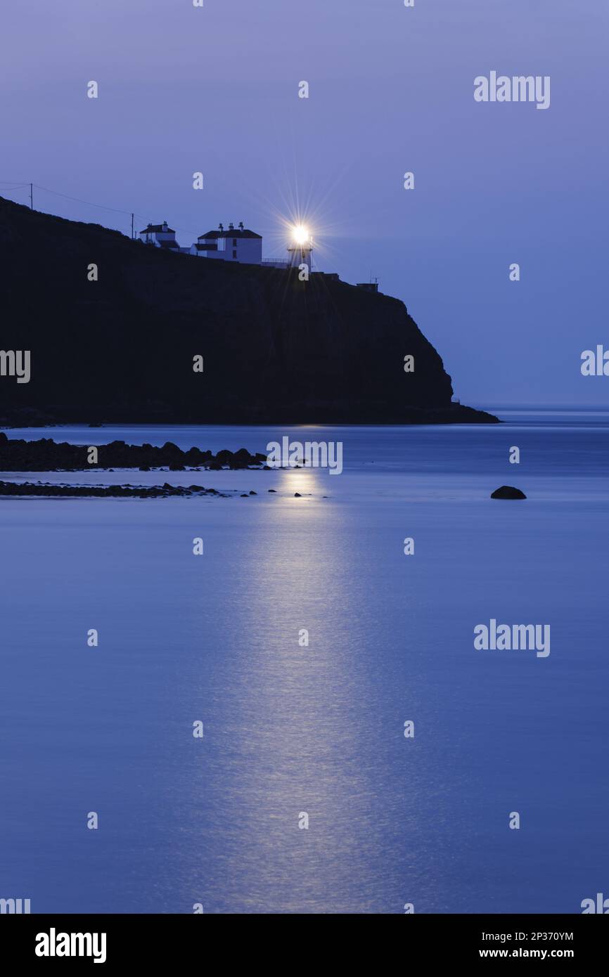 View of lighthouse on sea cliff at dusk, Blackhead lighthouse, Whitehead, County Antrim, Northern Ireland Stock Photo