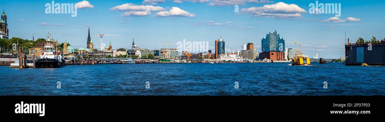 Panorama of the iconic skyline of bustling Hamburg harbor, featuring the famous landmarks Landungsbrücken, Elbphilharmonie and shipyard. Stock Photo