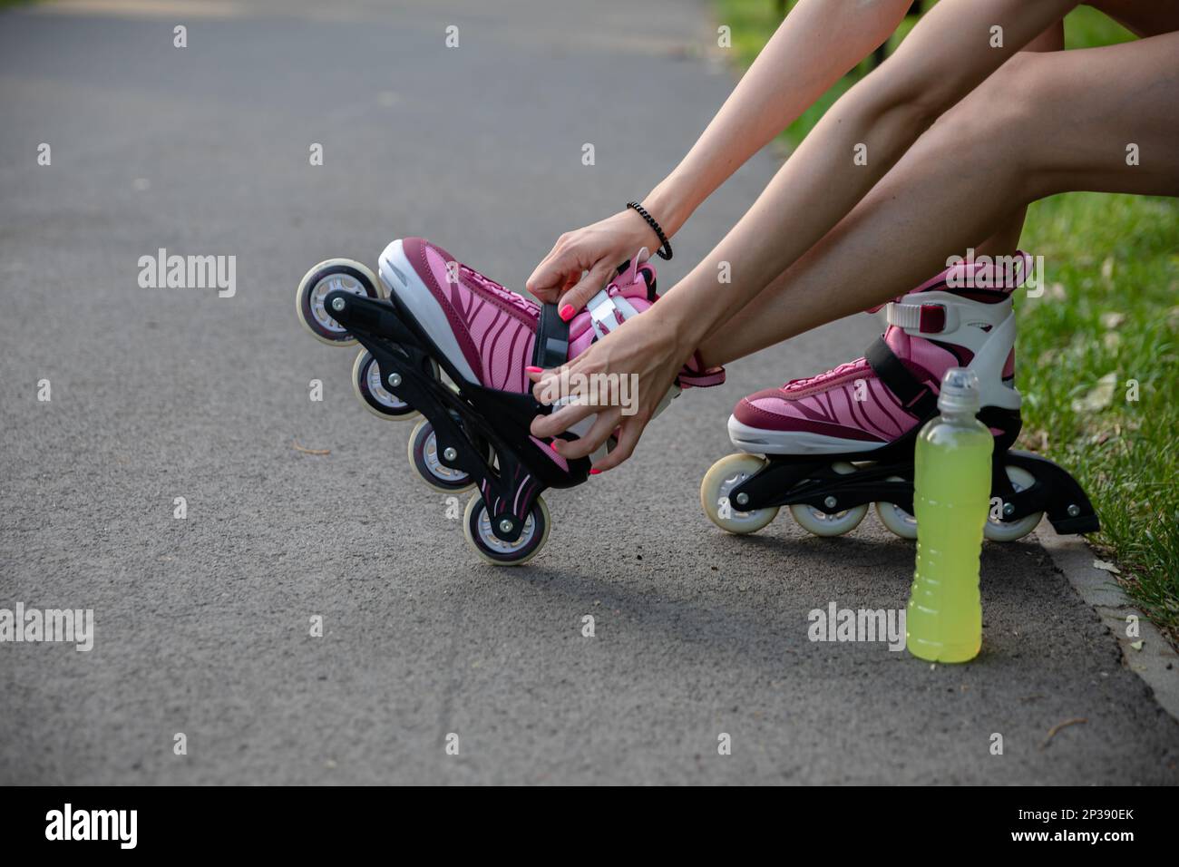 The girl prepares for training by putting on roller skates Stock Photo