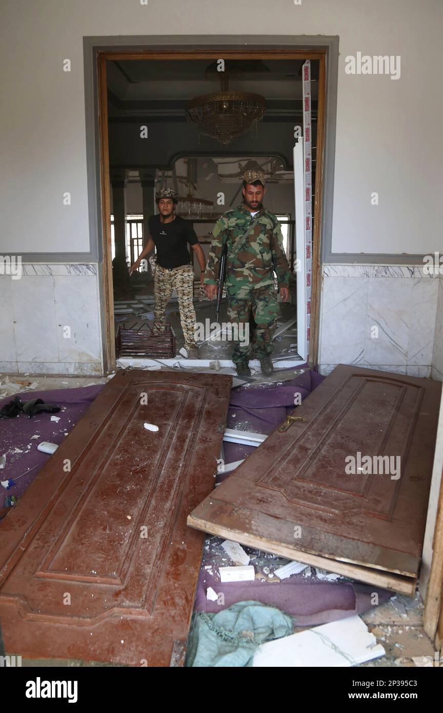 People inspect one of Saddam Hussein's palaces in Tikrit, 80 miles (130