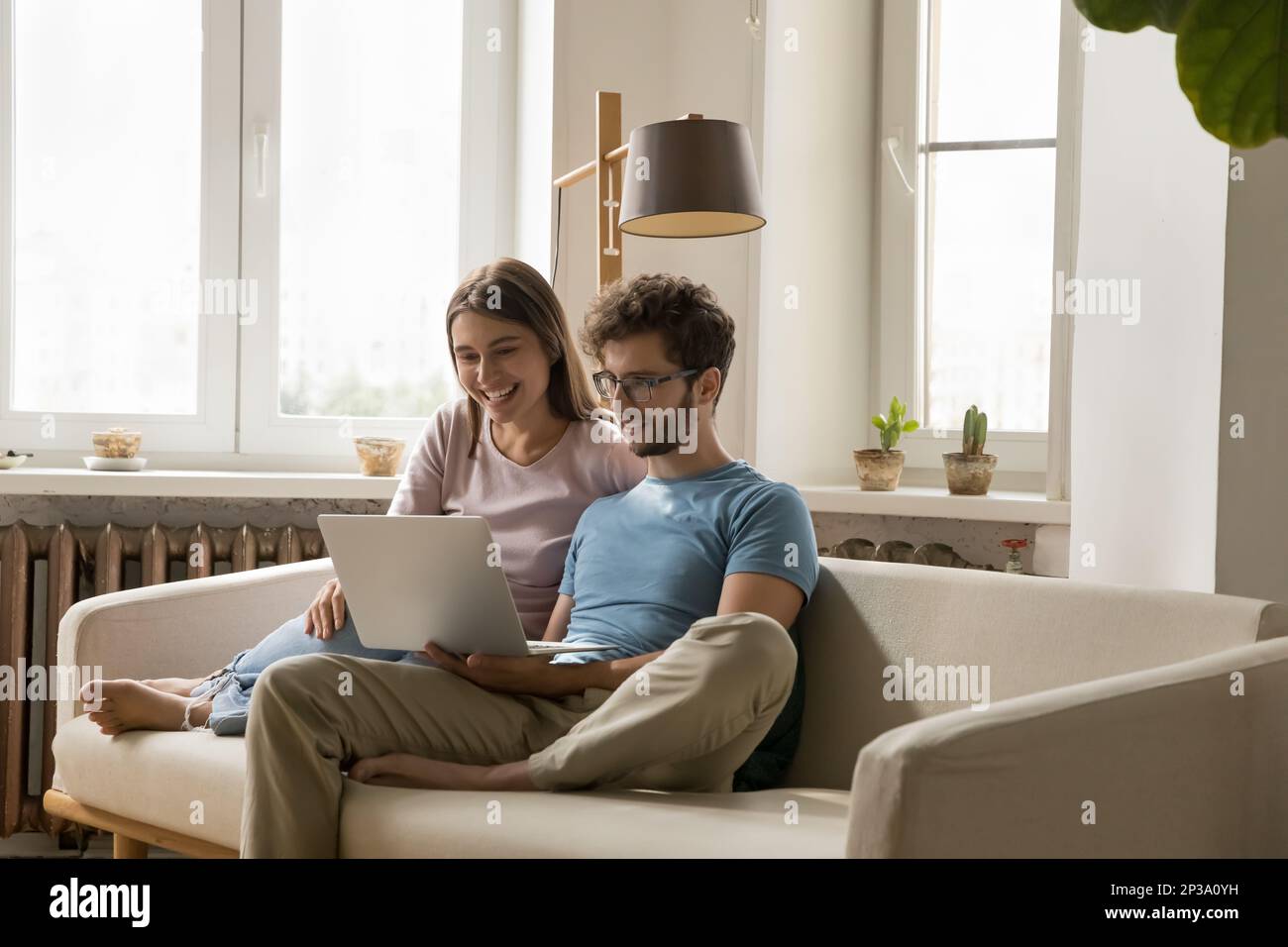 Happy focused young attractive couple speaking on video call Stock Photo