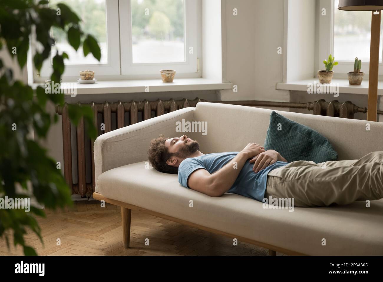 Exhausted peaceful sleepy young woman lying on back on couch Stock Photo