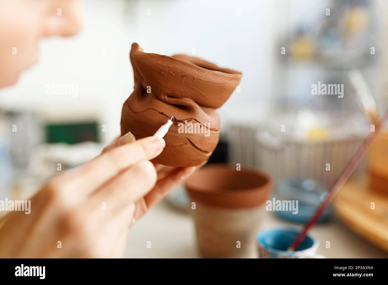 Female hands hold a bowl for casting clay products. Shaped method for
