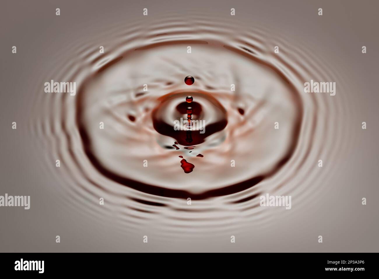 drop falling on soy sauce or brown liquid and created splash Stock Photo