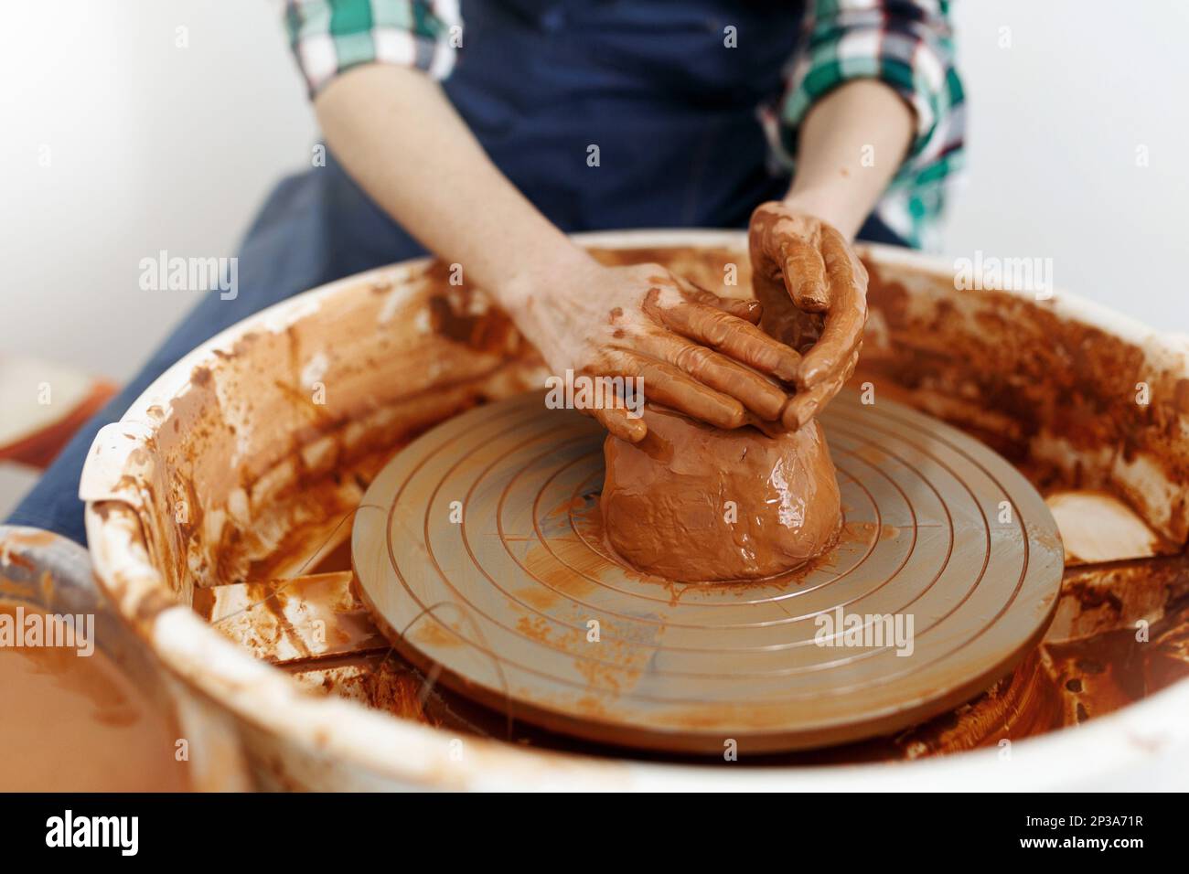 Cropped Image of Unrecognizable Female Ceramics Maker working with Pottery Wheel in Cozy Workshop Makes a Future Vase or Mug, Creative People Stock Photo