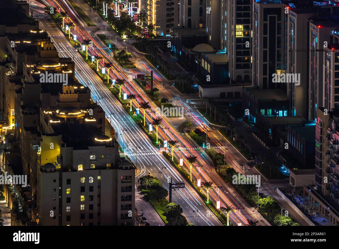 Dubai, UAE -  Dec 05 2021: Aerial view of highway traffic on the Palm Jumeirah Dubai at night with car light trails Stock Photo