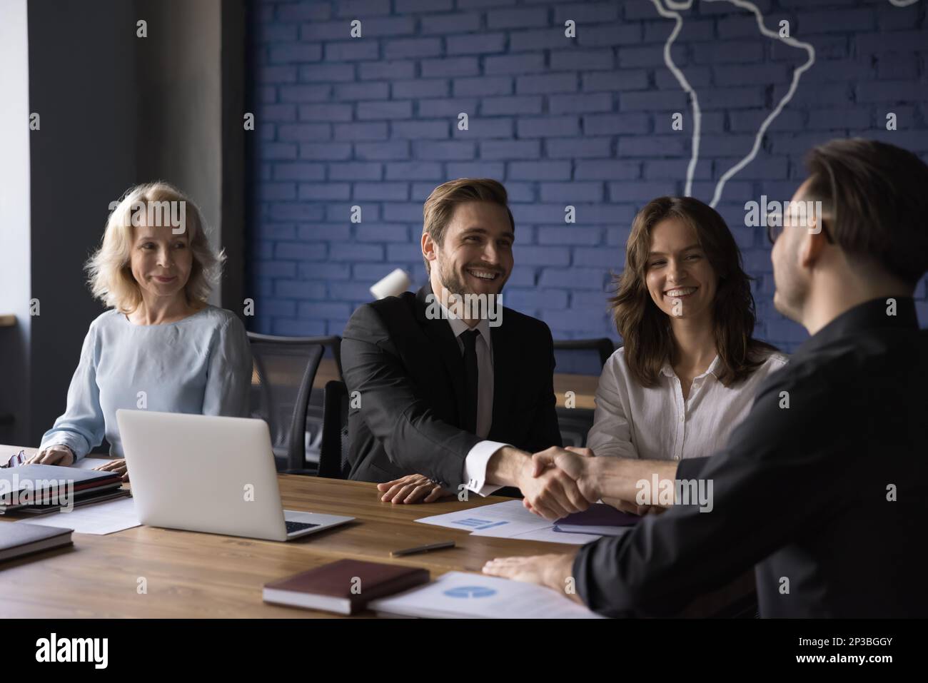 Happy confident business partner men shaking hands over meeting table Stock Photo