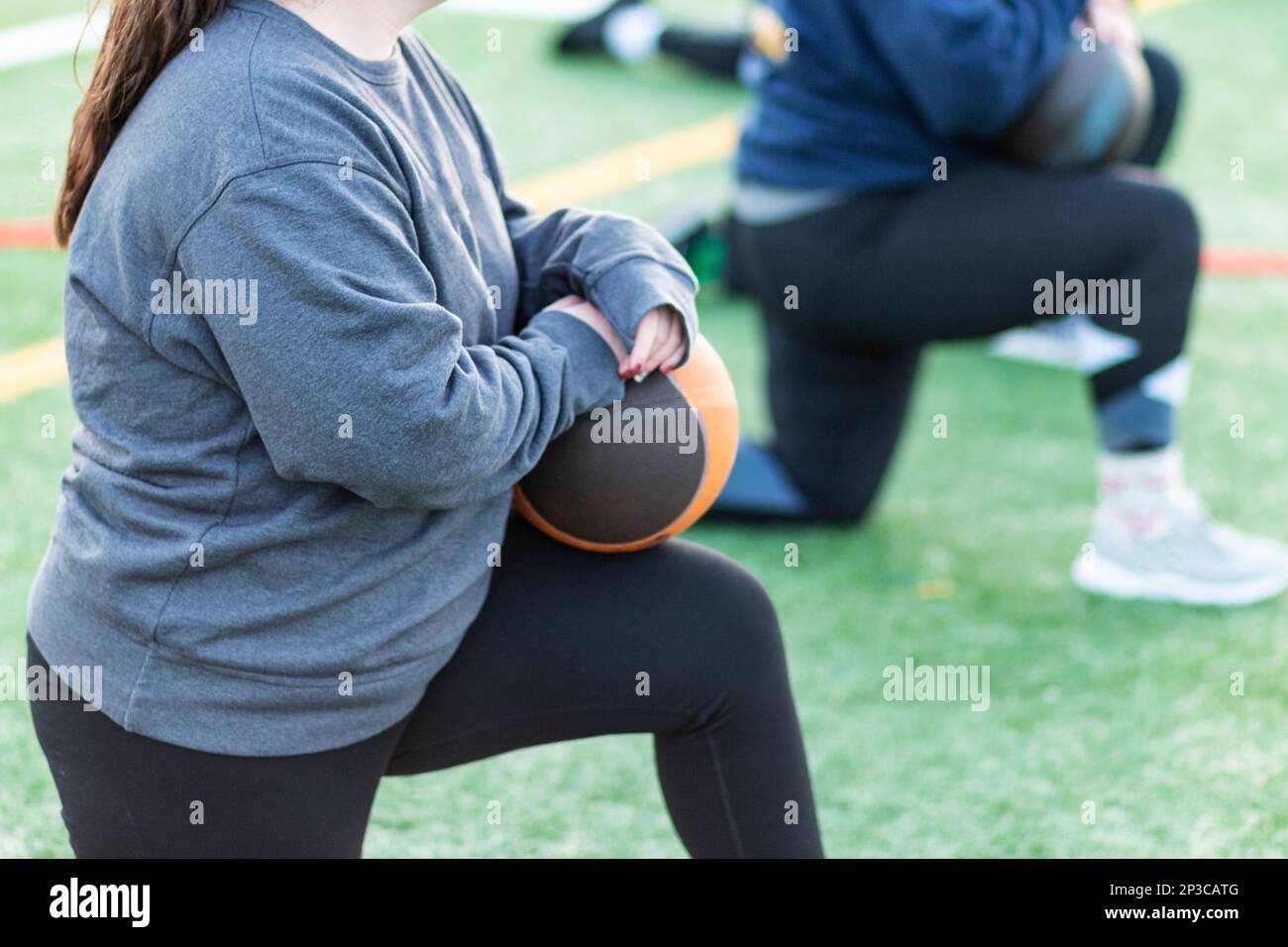 Female high school track and field throwing team resting on one knee