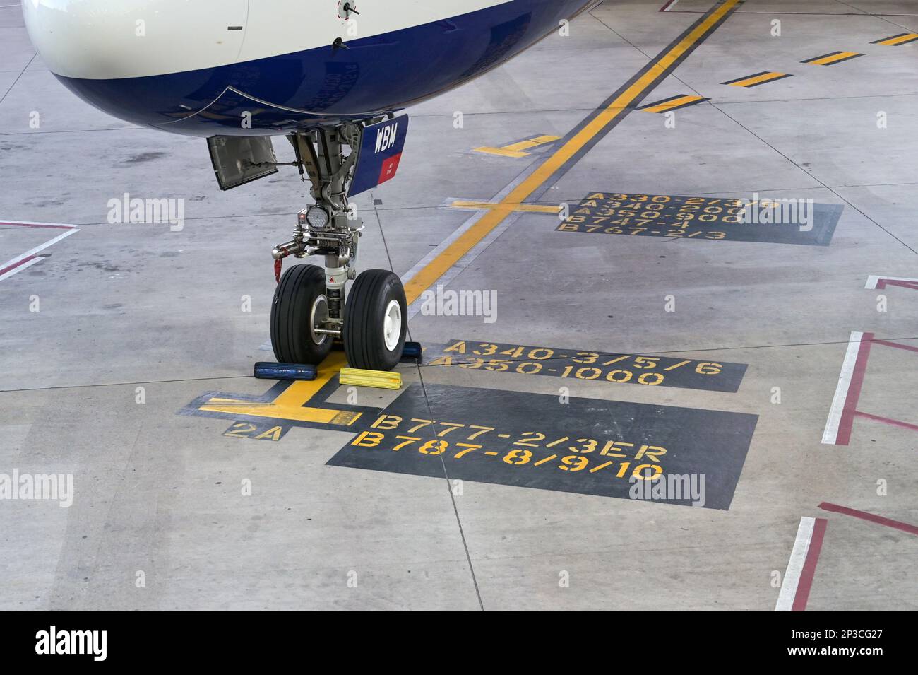 Austin, Texas - February 2023: Nose wheel of a British Airways Airbus A350 jet parked at the terminal on markings to show the stop point. Stock Photo