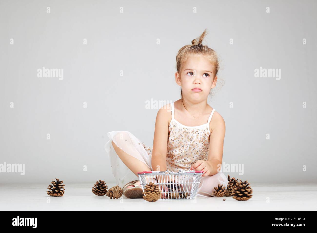 little caucasian girl playing with pinecones Stock Photo - Alamy