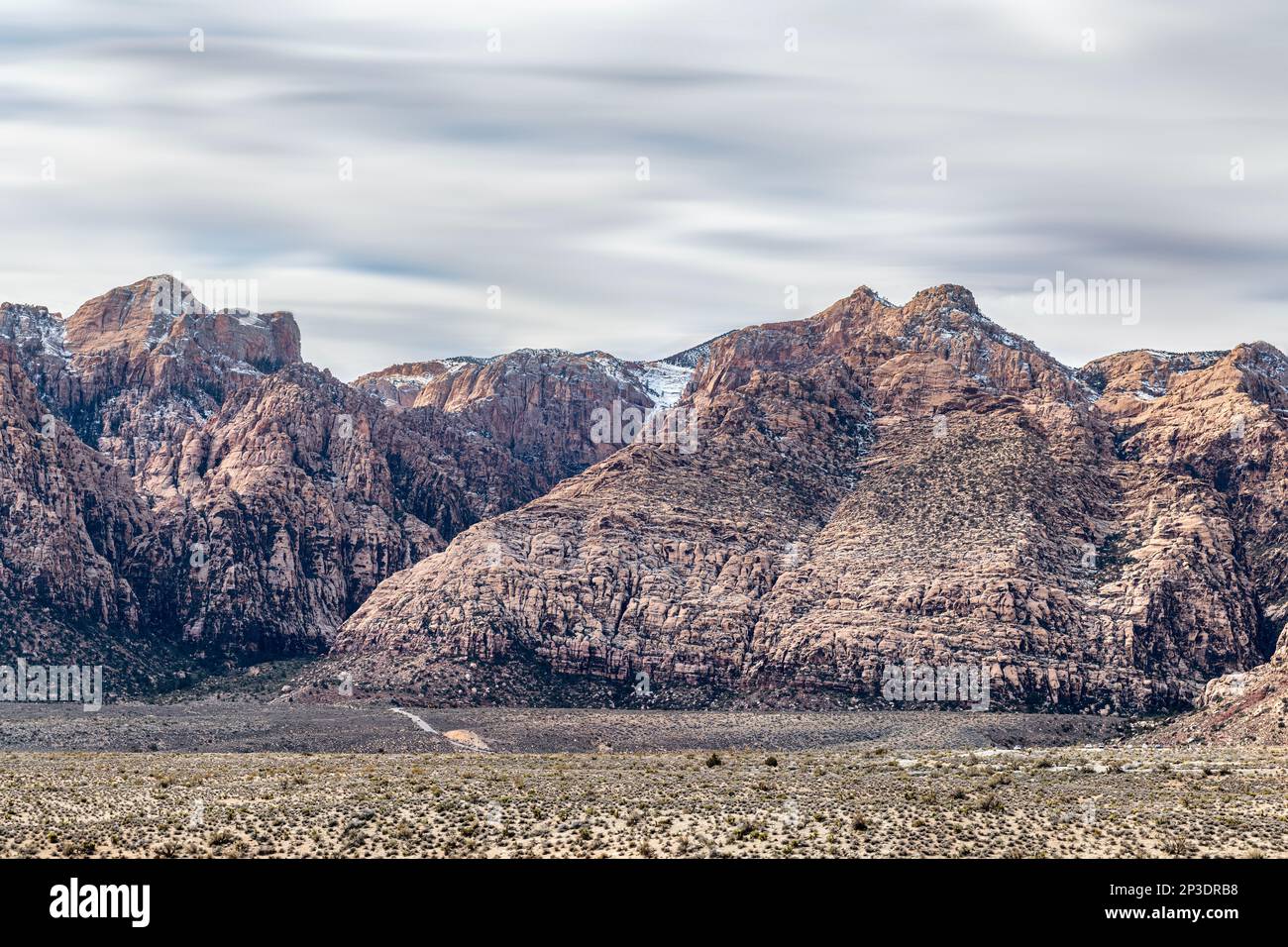 A long exposure of Red Rock Mountains shows the motion of the clouds and the intricate beauty of the wilderness in Las Vegas Nevada. Stock Photo