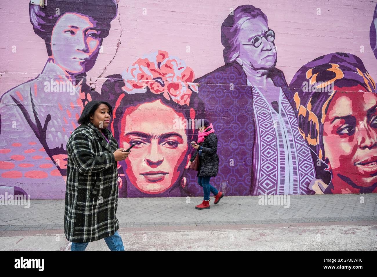 Madrid, Spain. 05th Mar, 2023. Women walk past a feminist mural ahead of a performance of a human chain to denounce violence against women and make visible the feminist struggle as part of the activities for International Women's Day. In the mural appear the faces of 15 women who are part of history for their fight in favor of equality such as Angela Davis, Frida Kahlo, Nina Simone, among others. Credit: Marcos del Mazo/Alamy Live News Stock Photo