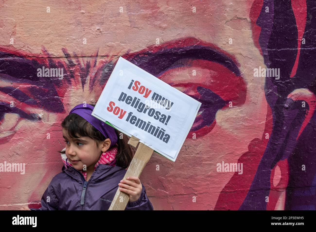Madrid, Spain. 05th Mar, 2023. A young girl holds a placard reading 'I am very dangerous. I am a feminist girl' standing in front of a feminist mural ahead of a human chain performance to denounce violence against women and make visible the feminist struggle. The human chain is part of the activities for International Women's Day. In the mural appear the faces of 15 women who are part of history for their fight in favor of equality such as Angela Davis, Frida Kahlo, Nina Simone, among others. Credit: Marcos del Mazo/Alamy Live News Stock Photo