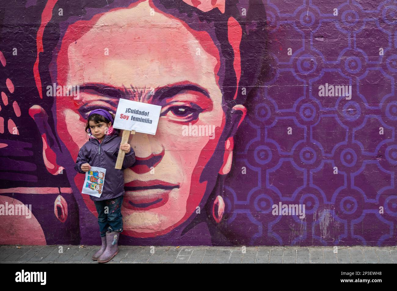 Madrid, Spain. 05th Mar, 2023. A young girl holds a placard reading 'Watch out I'm a feminist girl' standing in front of a feminist mural ahead of a a human chain performance to denounce violence against women and make visible the feminist struggle. The human chain is part of the activities for International Women's Day. In the mural appear the faces of 15 women who are part of history for their fight in favor of equality such as Angela Davis, Frida Kahlo, Nina Simone, among others. Credit: Marcos del Mazo/Alamy Live News Stock Photo