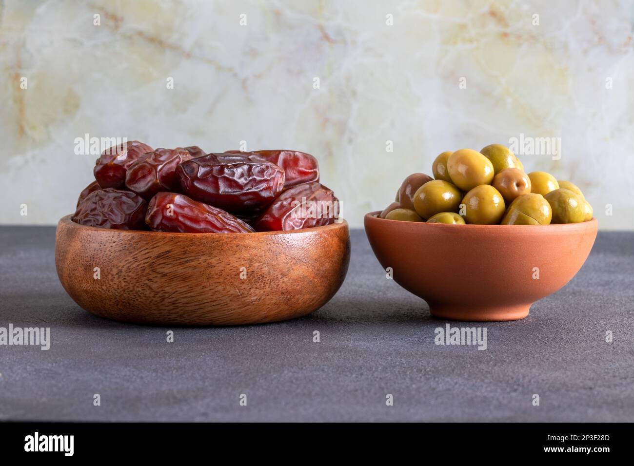 Dates fruit and green olives on a black background.Traditional iftar