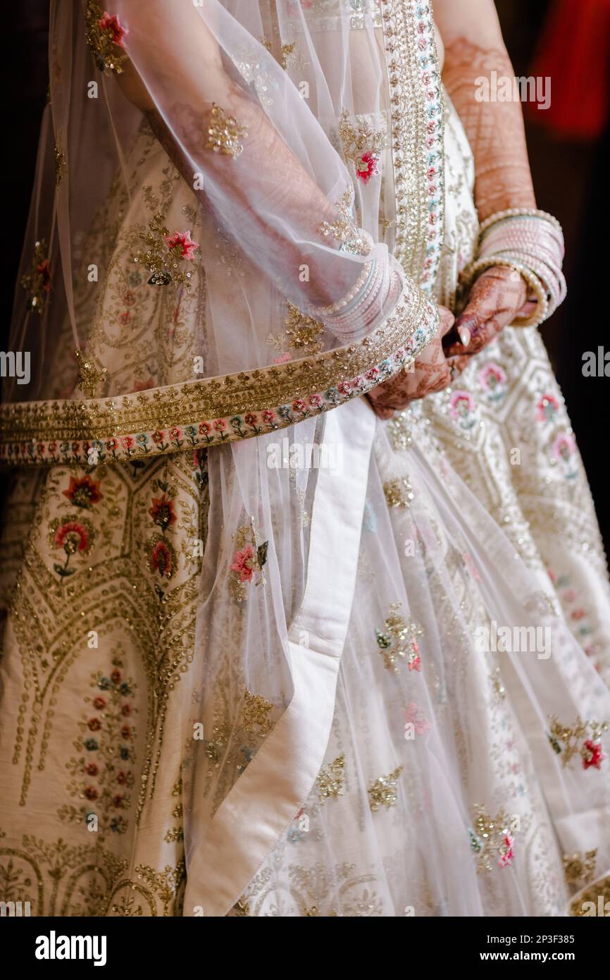 A newlywed Indian bride with nice henna tattoo design wearing a white  bridal dress Stock Photo - Alamy