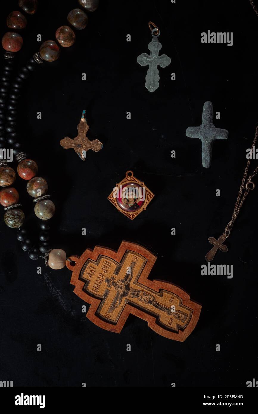 christian crucifix and rosary beads on abstract grey background
