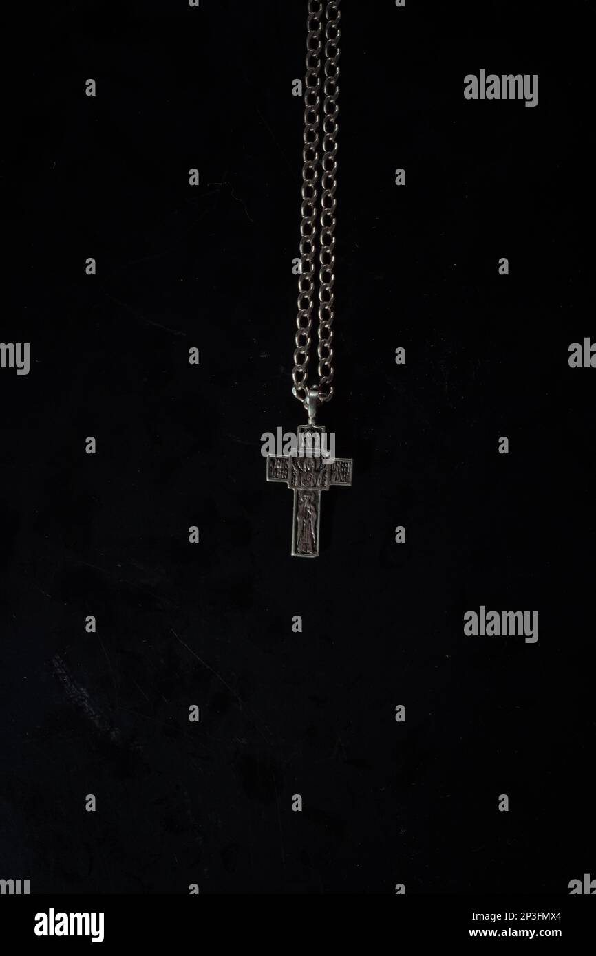 christian crucifix and rosary beads on abstract grey background
