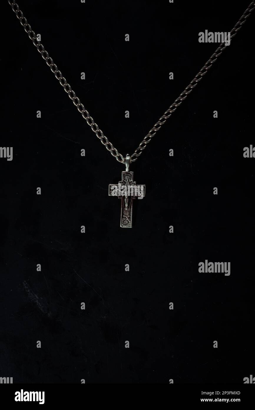 christian crucifix and rosary beads on abstract grey background